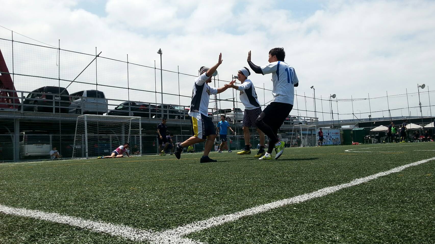 仲間とハイタッチをするフットサル利用シーン